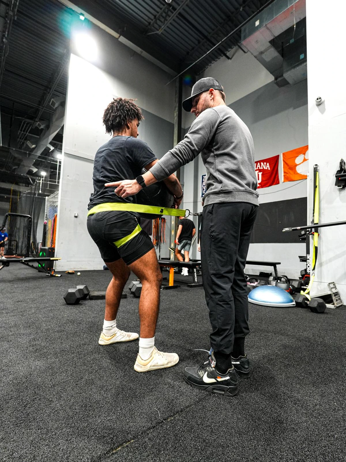 Coach working with an athlete in the weight room